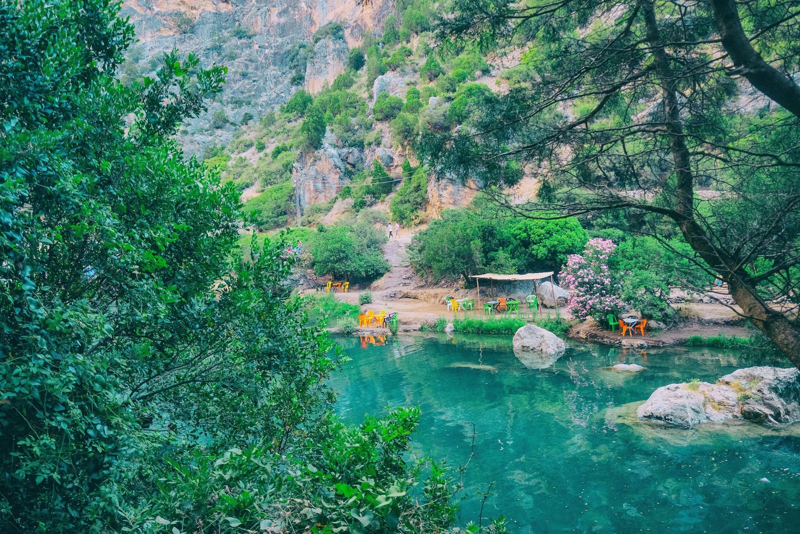 Turquoise water between green trees and cliffs at Akchour in Talassemtane park