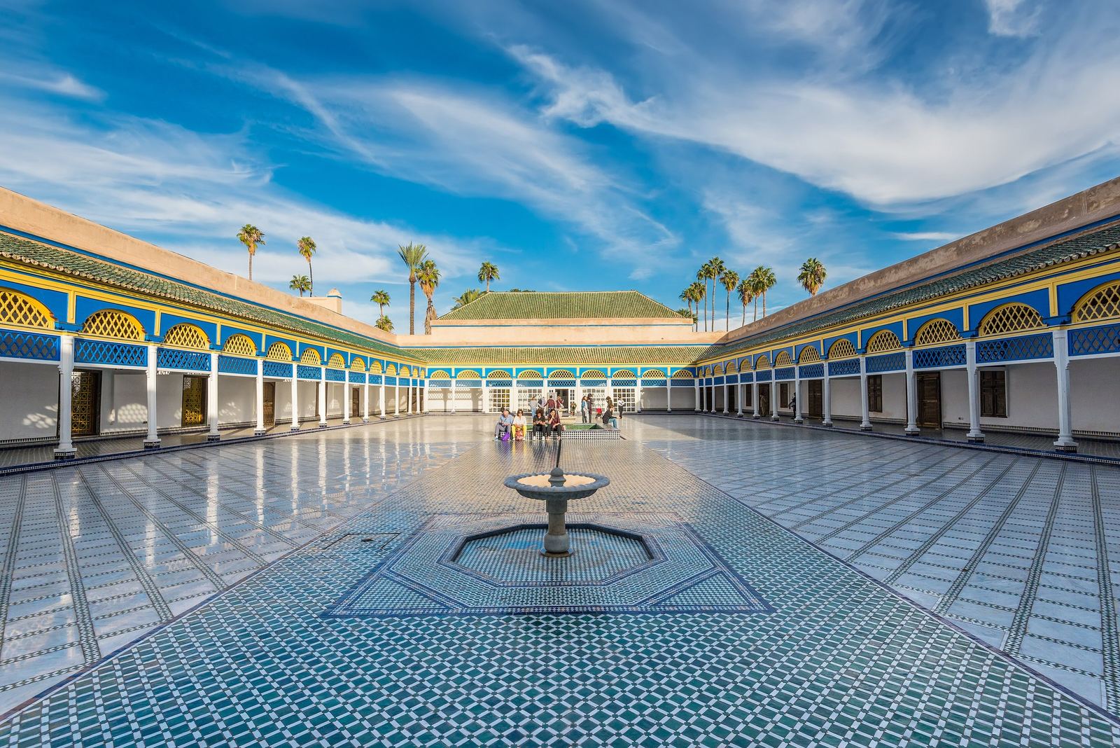 Marble courtyard with fountain and colonnades of the Bahia Palace under a blue sky