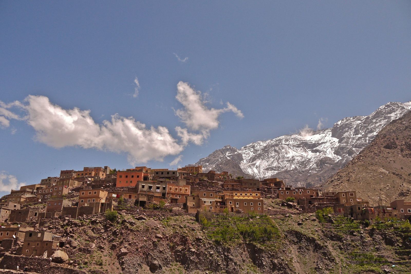 Earthen houses of the Berber village of Aroumd with snowy High Atlas peaks