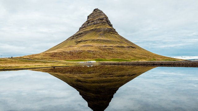 The pointed Kirkjufell mountain reflected in a calm lake on the Snæfellsnes peninsula