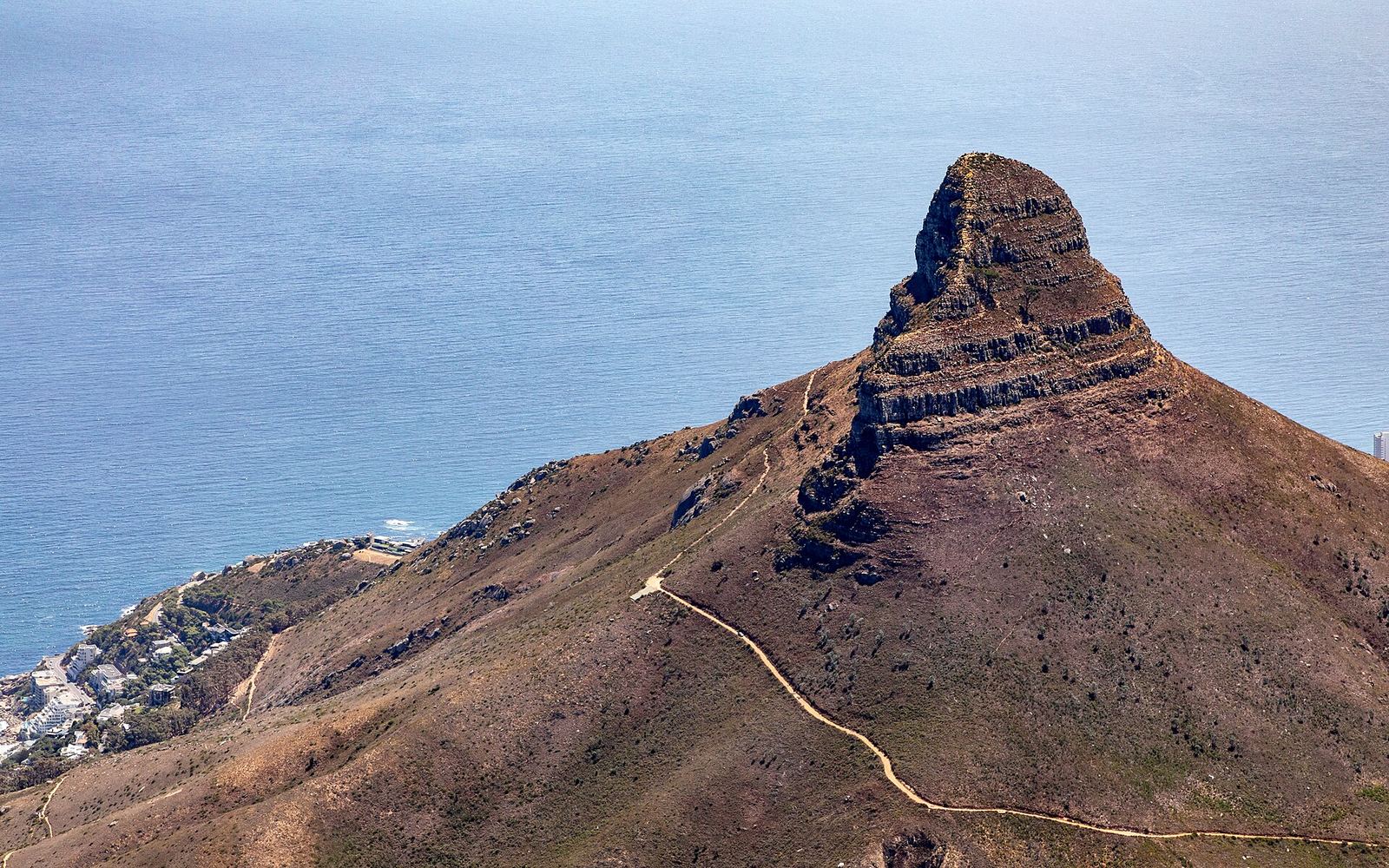 De top van Lion's Head gezien vanaf de Tafelberg, met Kaapstad en de kust