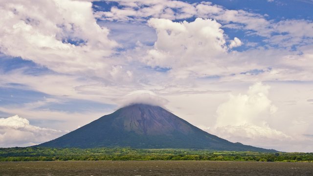 The cone of Concepción volcano on Ometepe island, a small cap cloud on its summit, seen across Lake Nicaragua